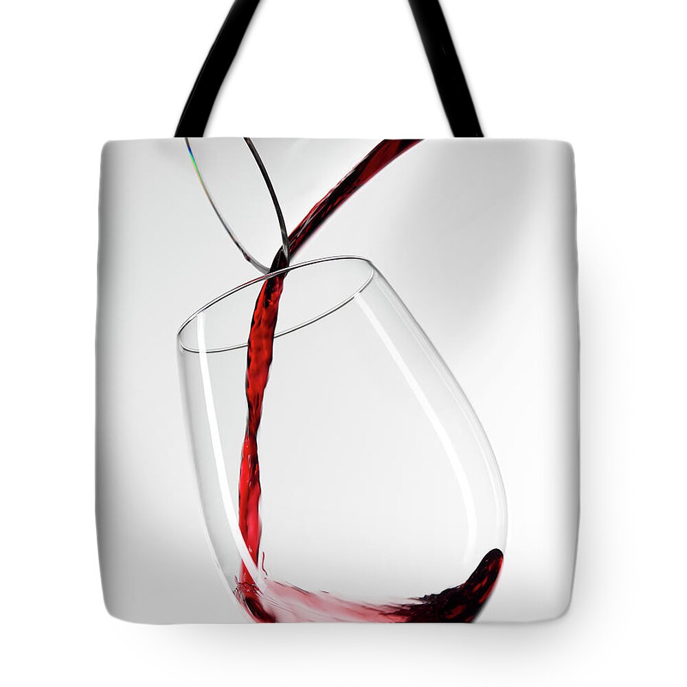 White Background Tote Bag featuring the photograph Red Wine Pouring Into Glass From by Roger Méndez Fotografo, S.l.