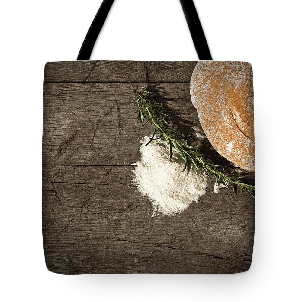 Bakery Tote Bag featuring the photograph Round Bread On A Wooden Table by Infrontphoto