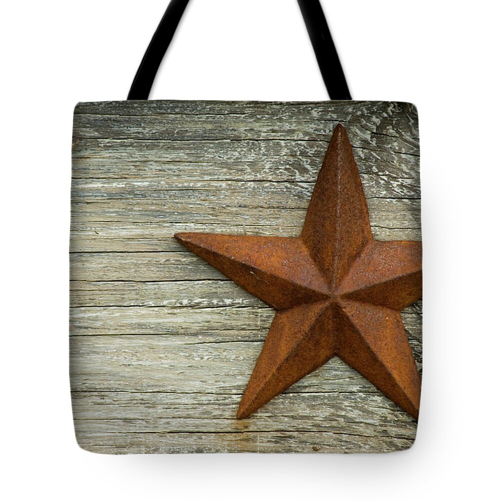 Wood Tote Bag featuring the photograph Rusted Texas Star On A Wooden Platform by Sdgamez