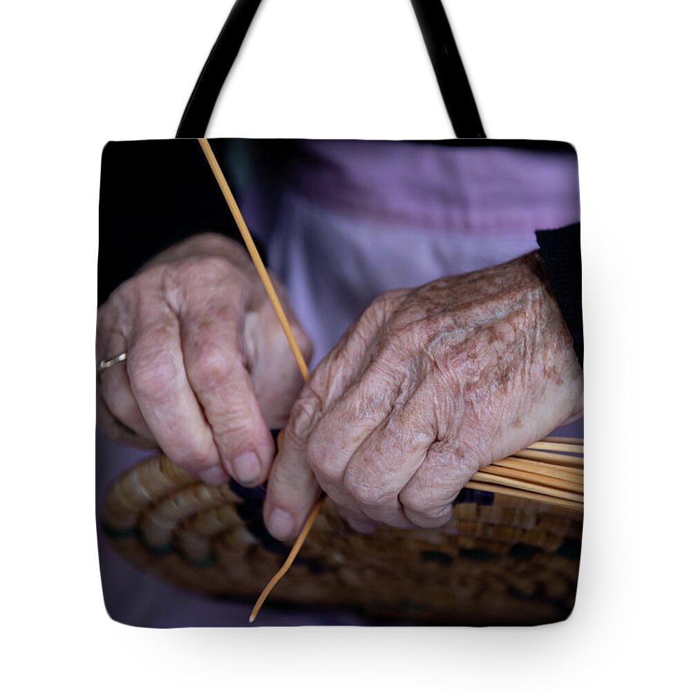 Knitting Tote Bag featuring the photograph Senior woman knitting a traditional basket with reeds  by Michalakis Ppalis