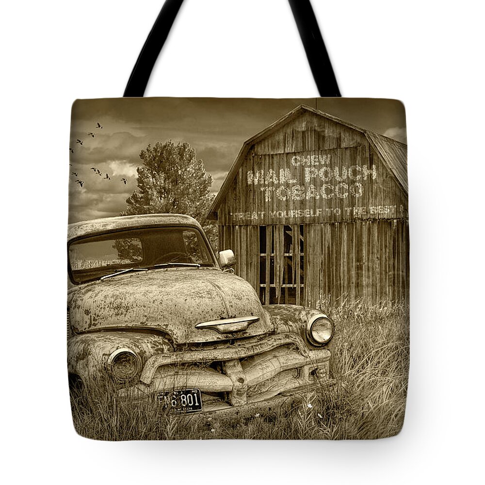 Chevy Tote Bag featuring the photograph Sepia Tone of Rusted Chevy Pickup Truck in a Rural Landscape by a Mail Pouch Tobacco Barn by Randall Nyhof