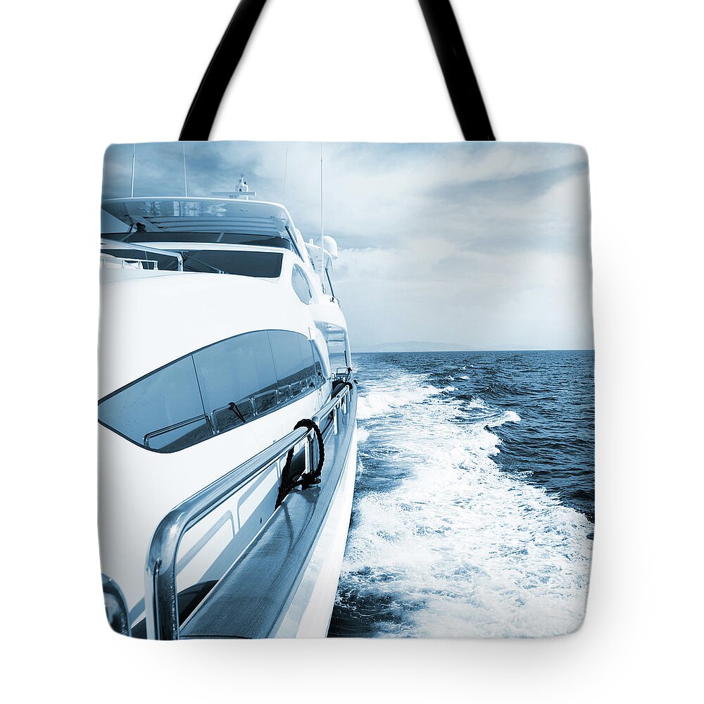 Desaturated Tote Bag featuring the photograph Side View Of Luxury Yacht Sailing The by Petreplesea