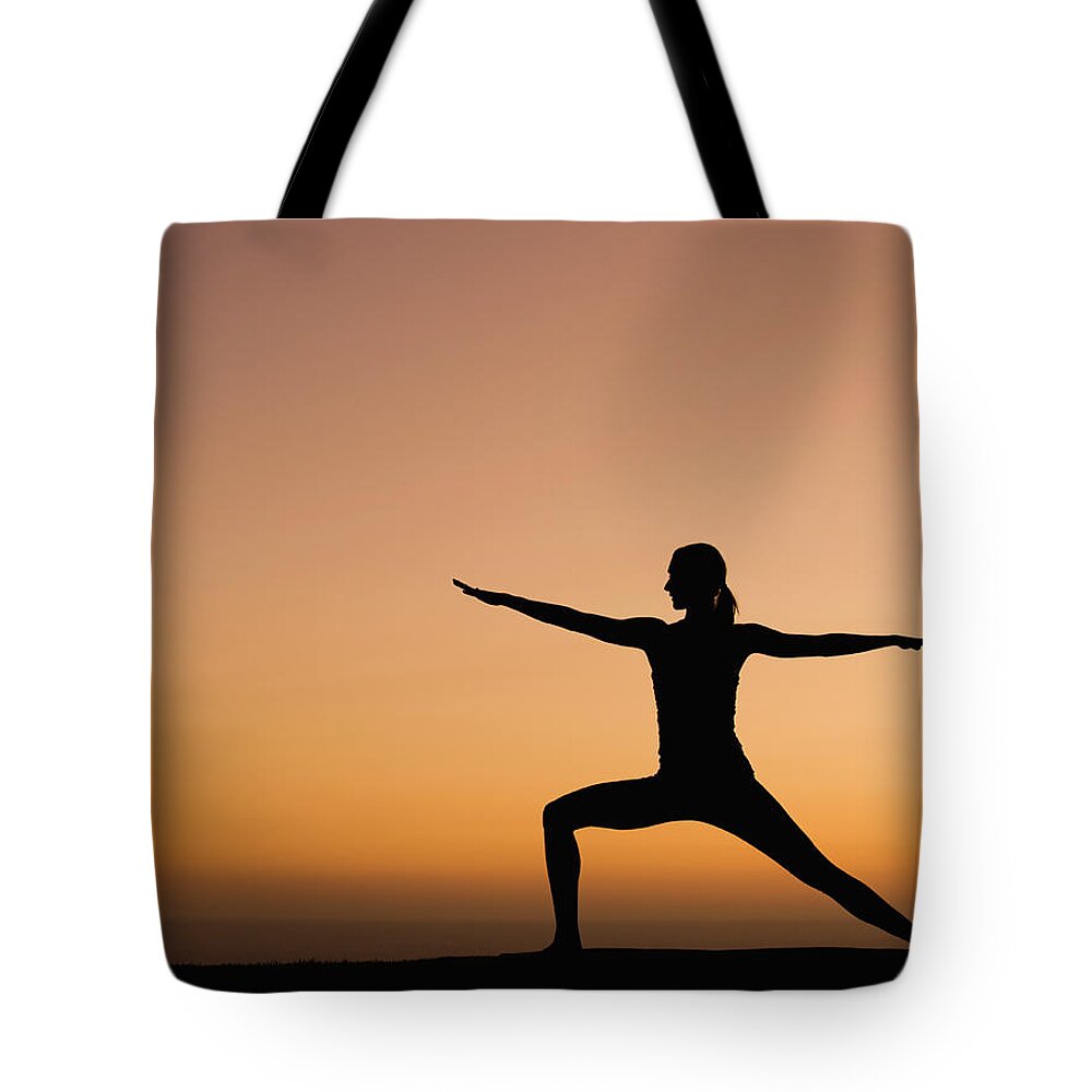Tranquility Tote Bag featuring the photograph Silhouette Of Woman Doing Yoga by Erik Isakson