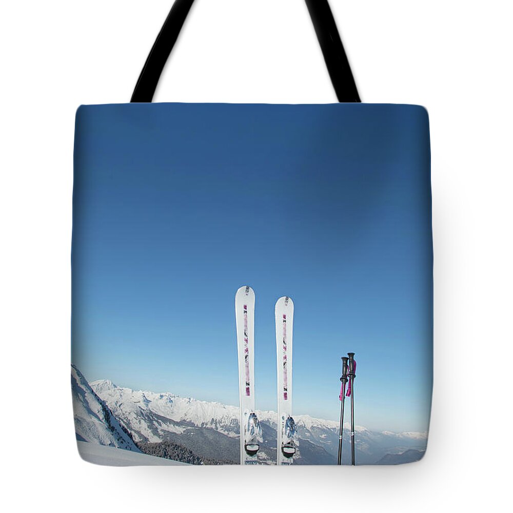 Ski Pole Tote Bag featuring the photograph Skis And Ski Poles Stuck In The Snow by L.a. Novia