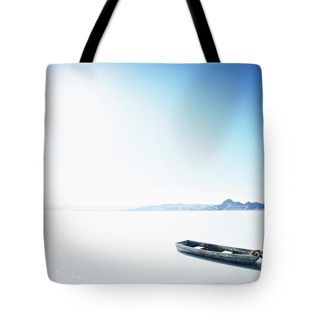 Tranquility Tote Bag featuring the photograph Small Boat Floating In Water Under by Thomas Barwick