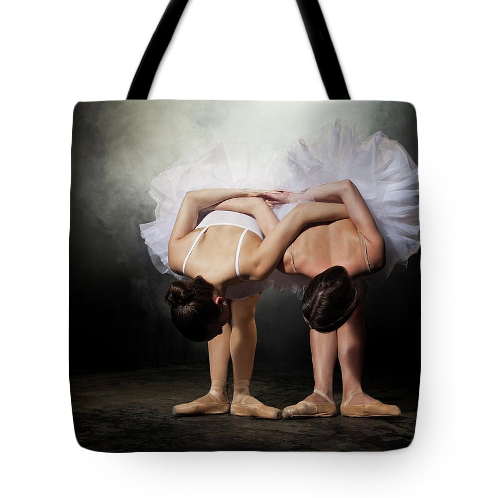 Ballet Dancer Tote Bag featuring the photograph Two Ballerinas Stretching On Stage by Nisian Hughes