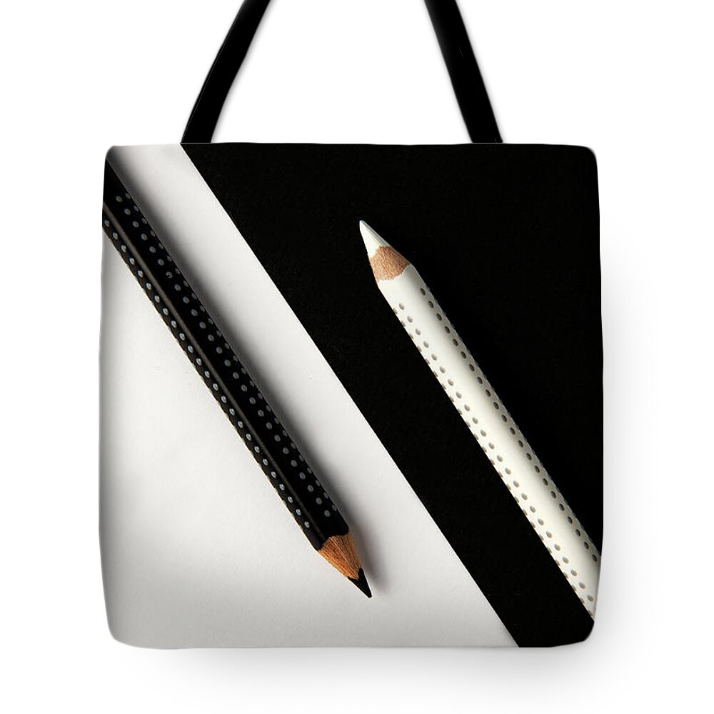 Pencil Tote Bag featuring the photograph Two drawing pencils on a black and white surface. by Michalakis Ppalis
