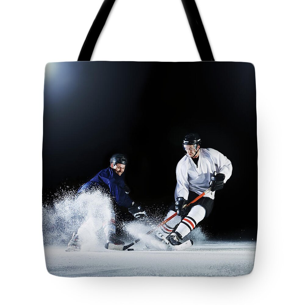 Young Men Tote Bag featuring the photograph Two Ice Hockey Players Challenging For by Robert Decelis Ltd