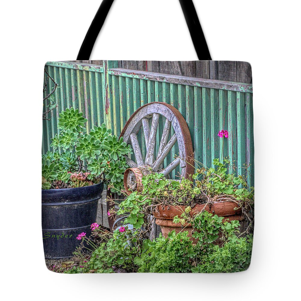 Wagon Wheels And Potted Plants Tote Bag featuring the photograph Wagon Wheels and Potted Plants by Barbara Snyder