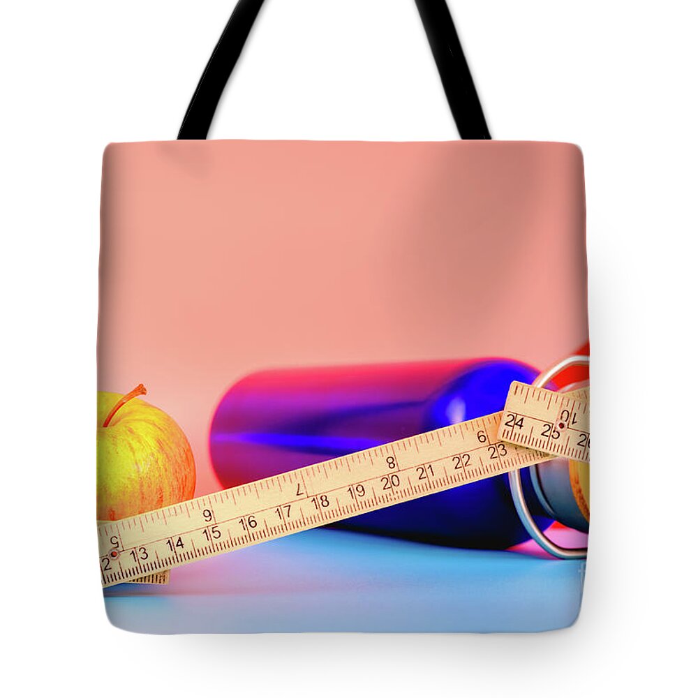 Apple Tote Bag featuring the photograph Water bottle, apple and measuring tape isolated on colorful background in studio, healthy life concept. by Joaquin Corbalan