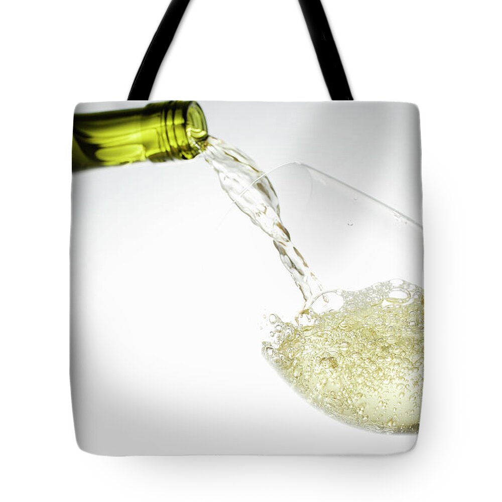 White Background Tote Bag featuring the photograph White Wine Pouring Into Glass by Brett Stevens