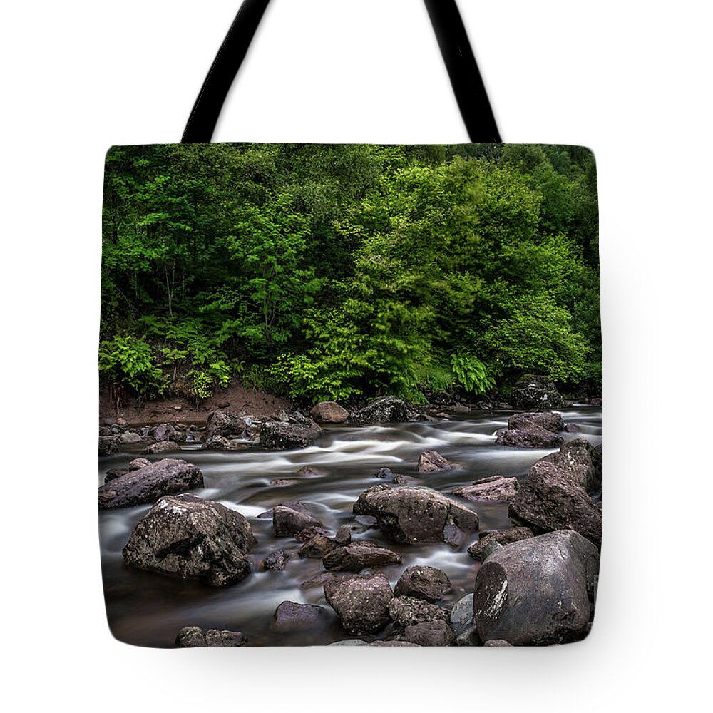 Background Tote Bag featuring the photograph Wild Mountain River Streaming Through Green Forest in Scotland by Andreas Berthold