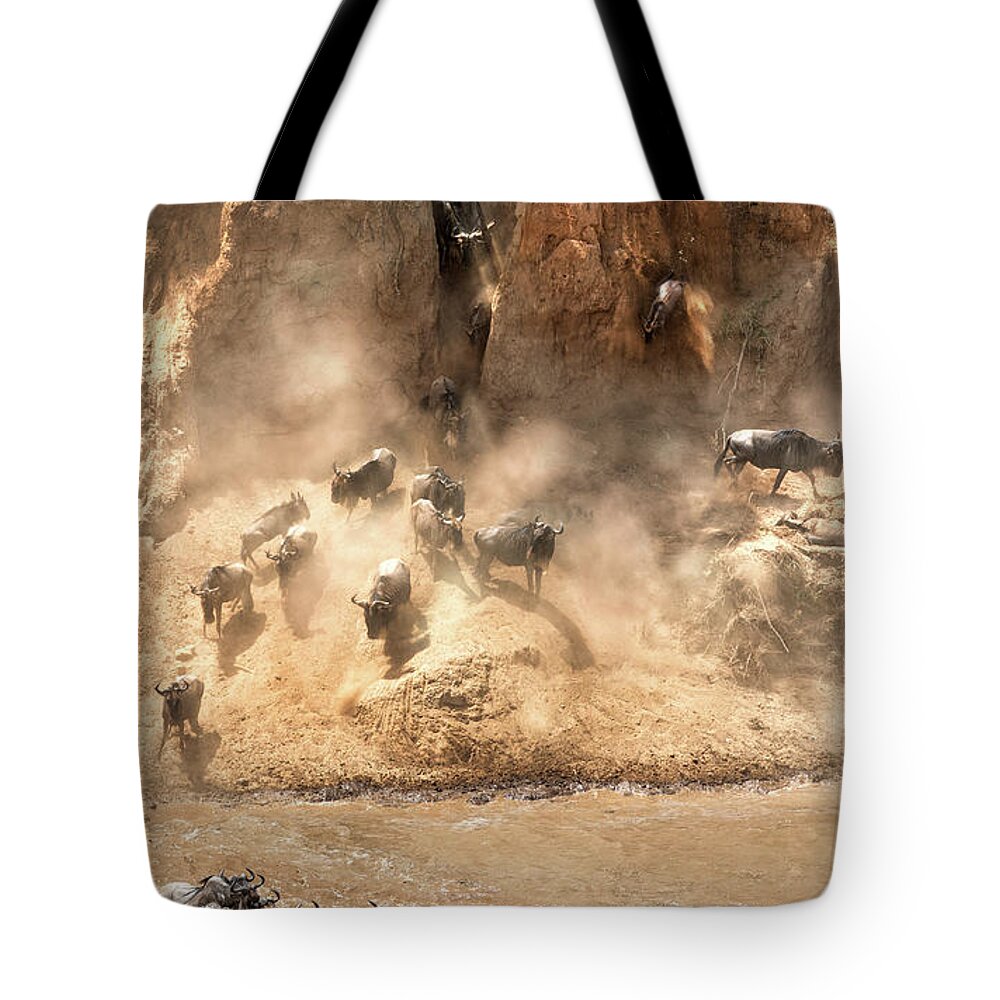 Mara Tote Bag featuring the photograph Wildebeest jump from the banks of the Mara by Jane Rix