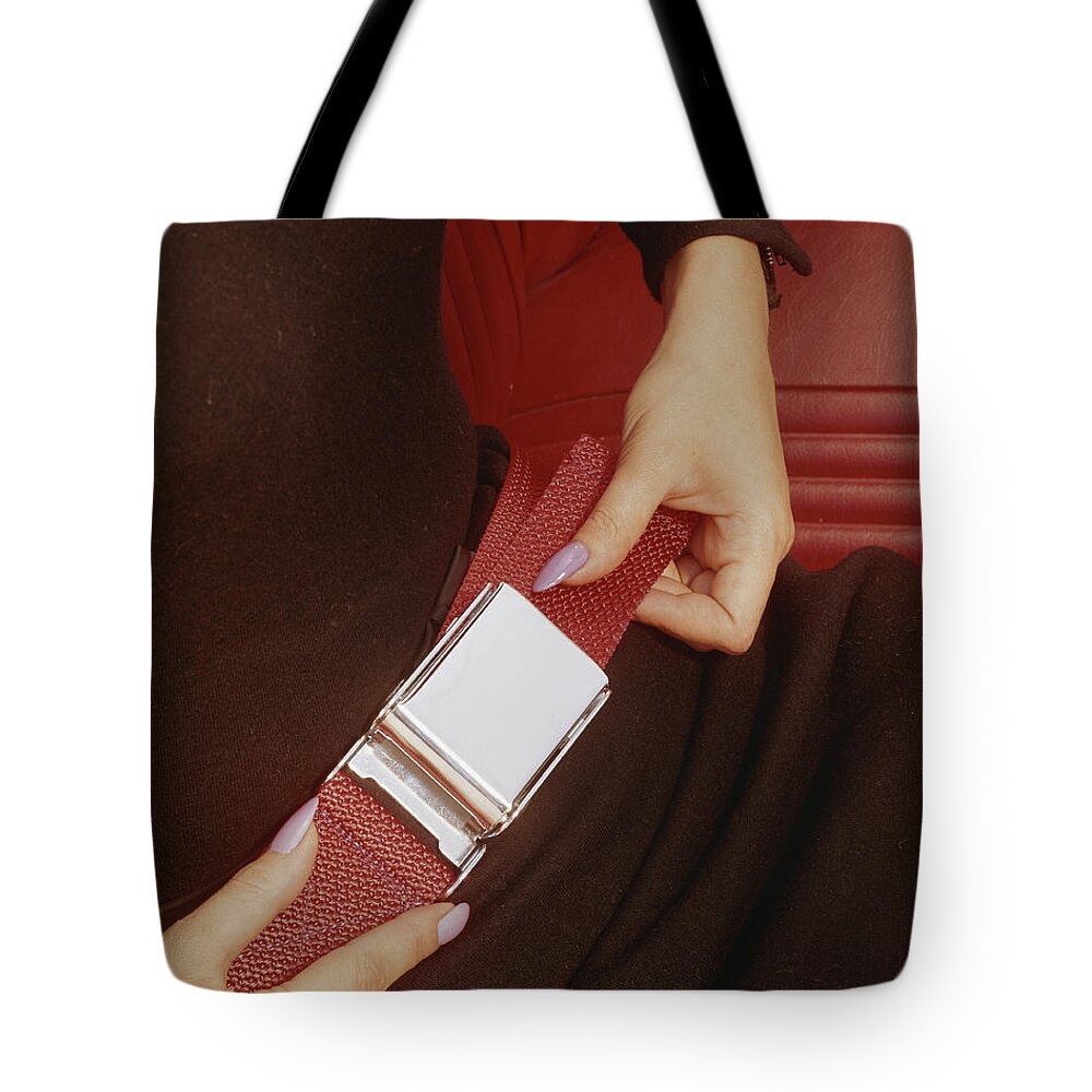 People Tote Bag featuring the photograph Woman Fastening His Seatbelt, Close-up by Tom Kelley Archive
