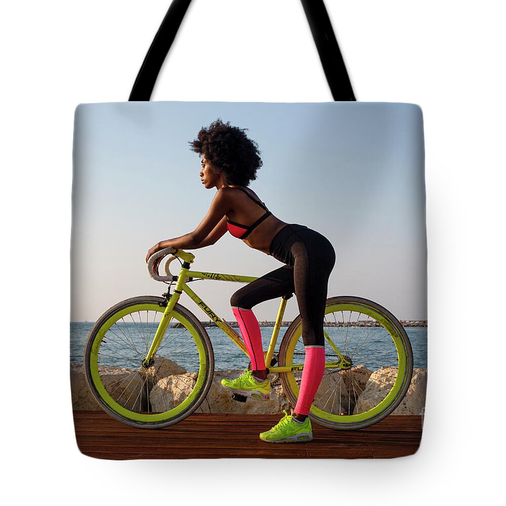 Young Tote Bag featuring the photograph Young athletic woman with bicycle k2 by Ami Siano