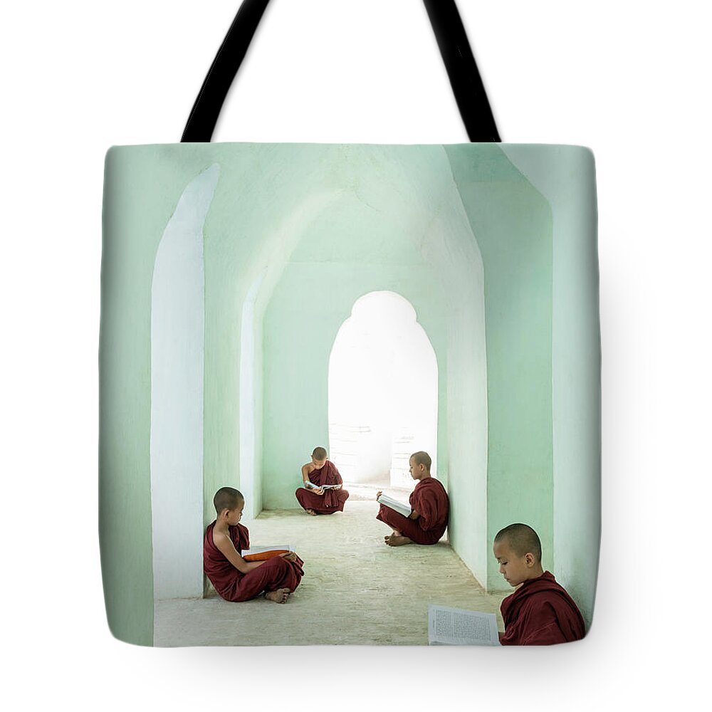 Arch Tote Bag featuring the photograph Young Buddhist Monks Reading In Temple by Martin Puddy