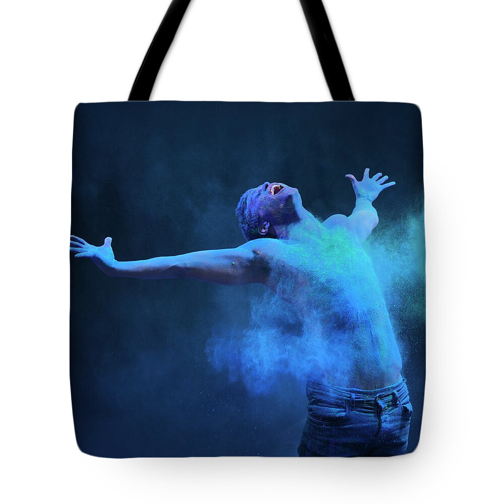 Art Tote Bag featuring the photograph Young Man In Spray Of Colored Powder by Henrik Sorensen