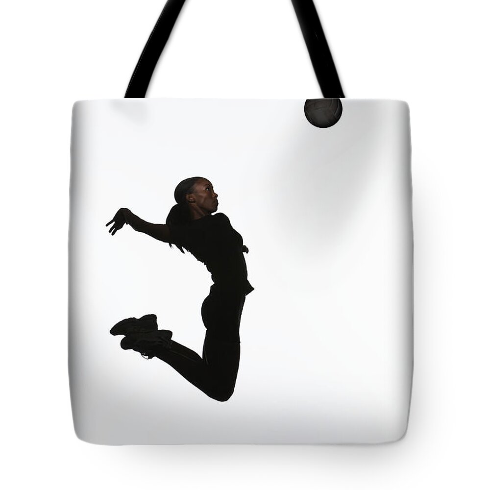 Human Arm Tote Bag featuring the photograph Young Woman Jumping In Air, Reaching To by Paul Taylor
