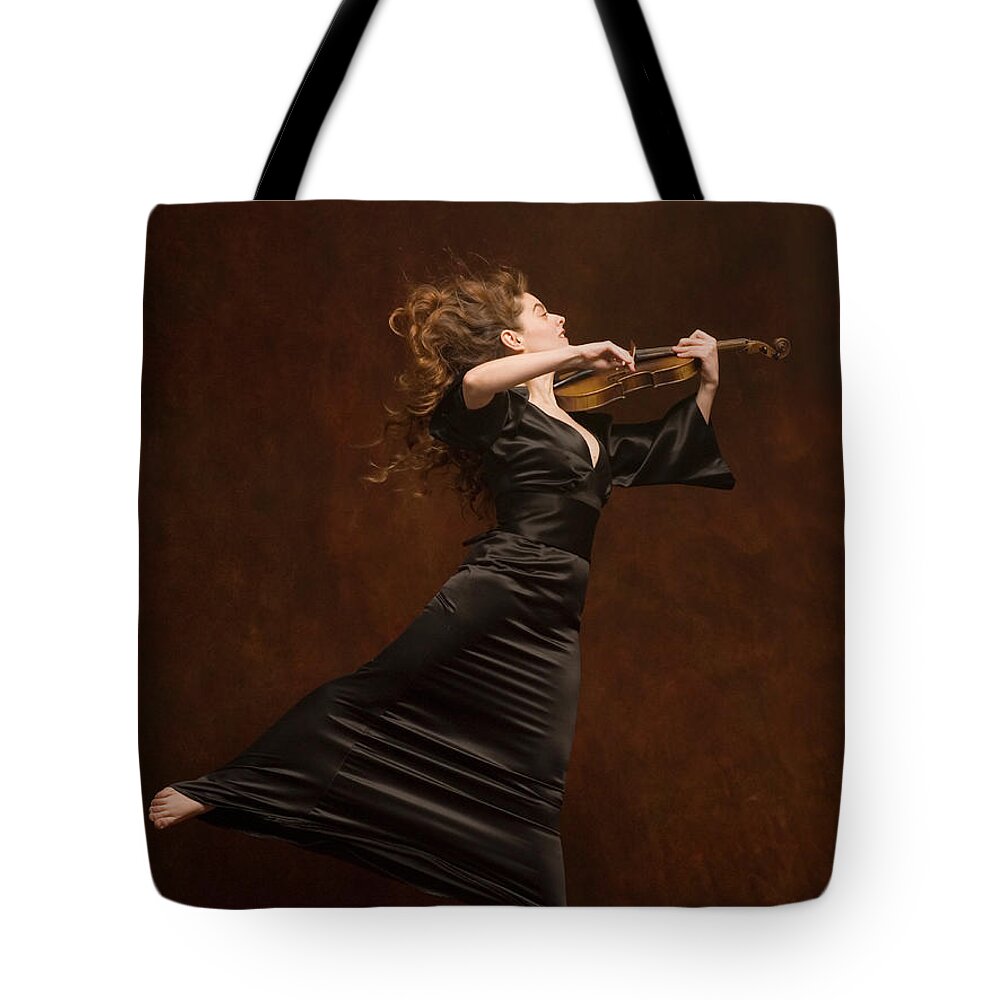 Expertise Tote Bag featuring the photograph Young Woman Playing Violin And Jumping by Pm Images