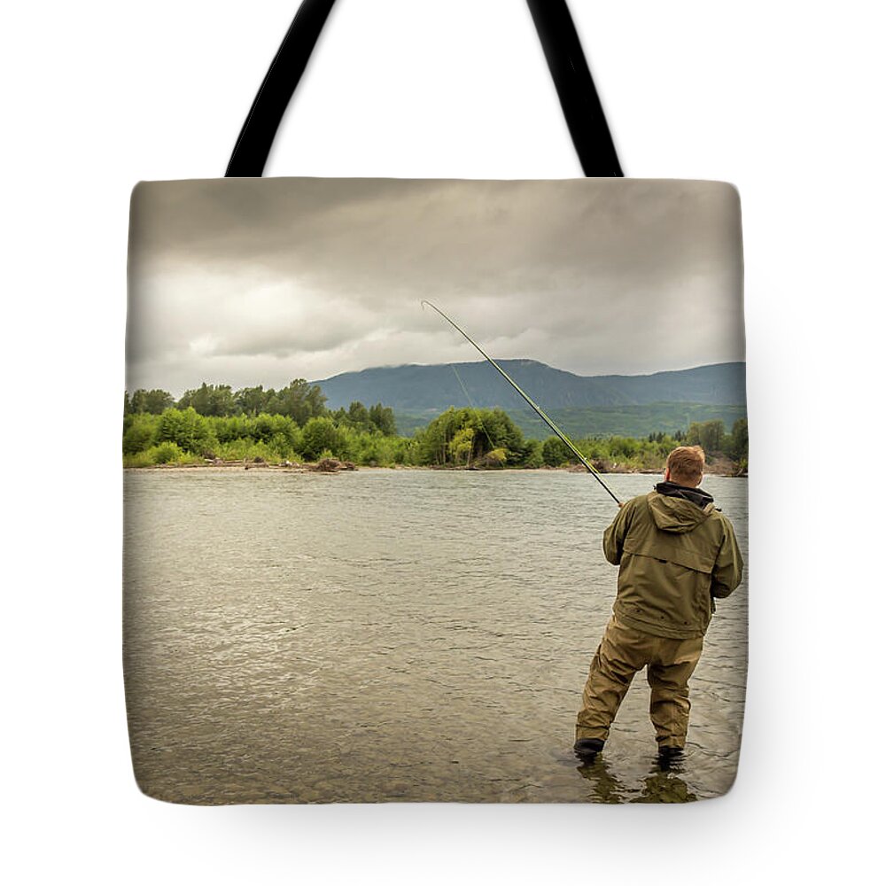Fisherman battling a fish with a bent rod, while wading. #2 Tote