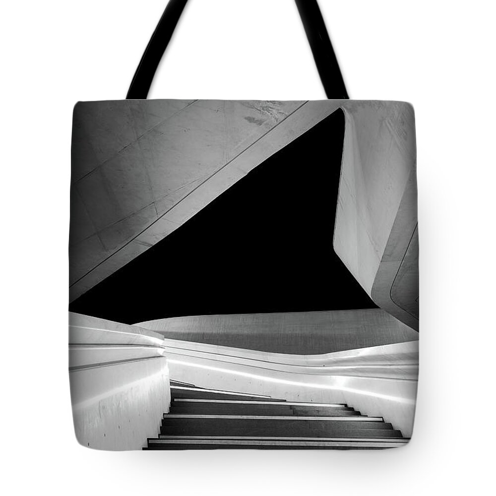 Futuristic Building Tote Bag featuring the photograph Modern architecture and empty staircase leading to a bright open space. by Michalakis Ppalis