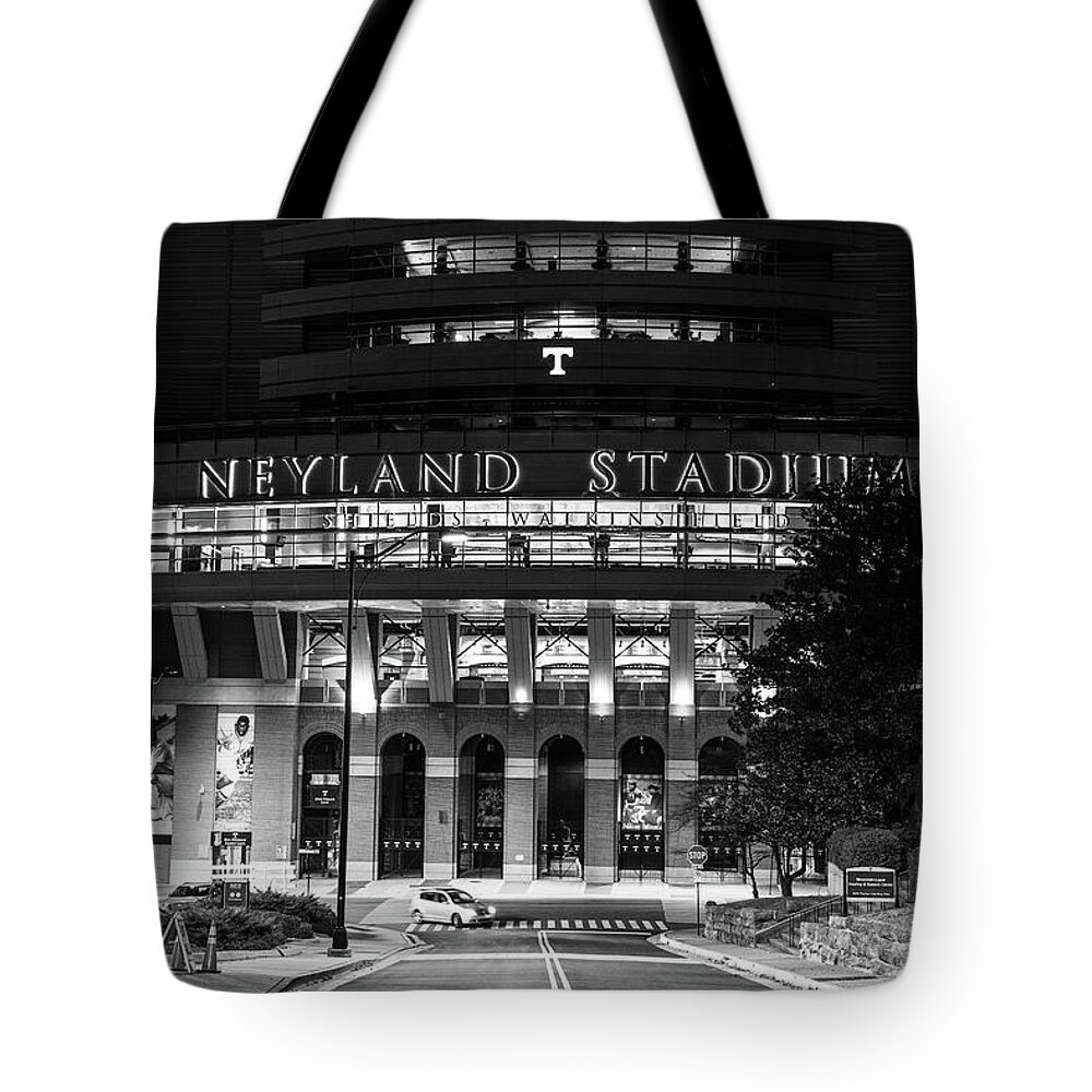 University Of Tennessee At Night Tote Bag featuring the photograph Neyland Stadium at the University of Tennessee at night in black and white #1 by Eldon McGraw