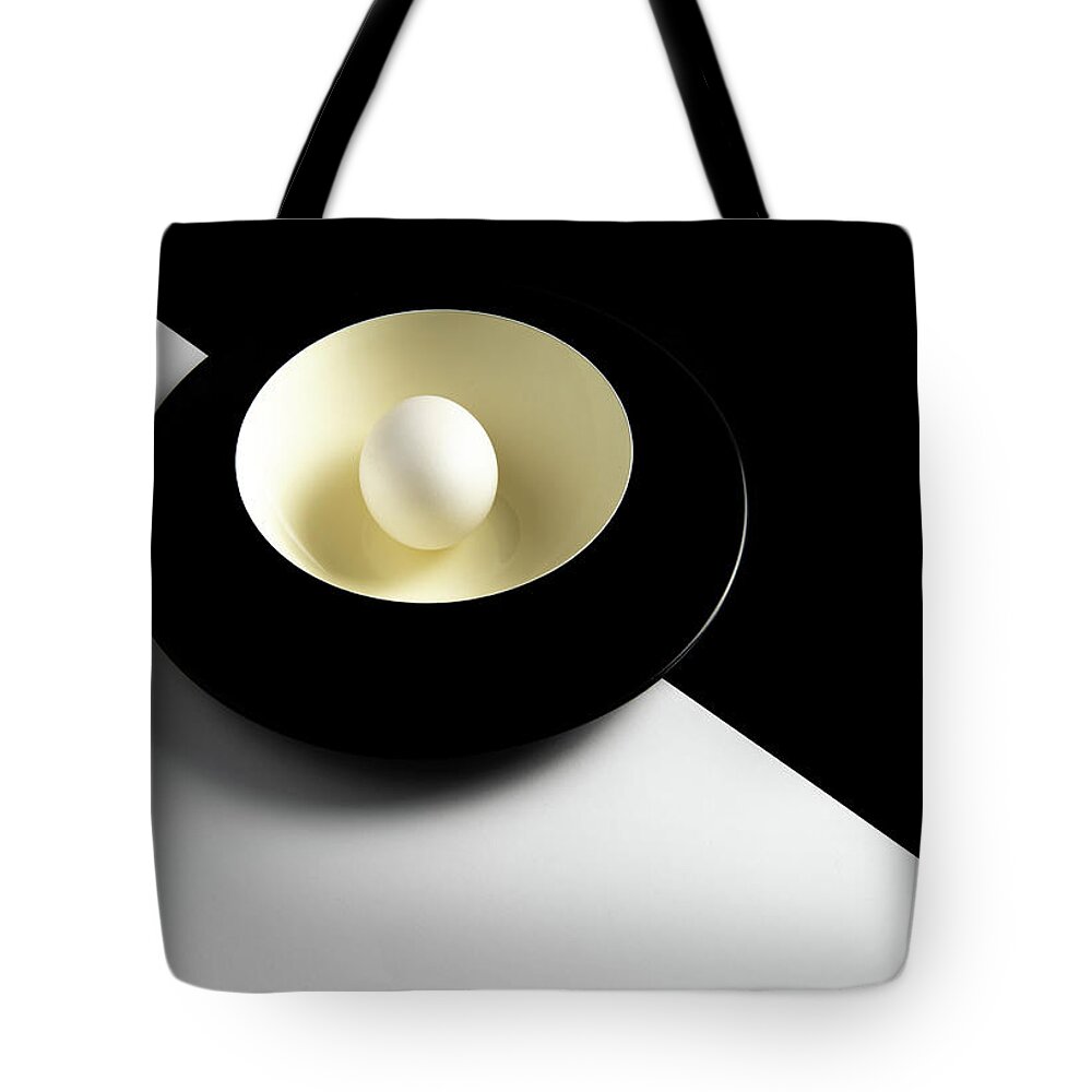 Still-life Tote Bag featuring the photograph Single fresh white egg on a yellow bowl by Michalakis Ppalis
