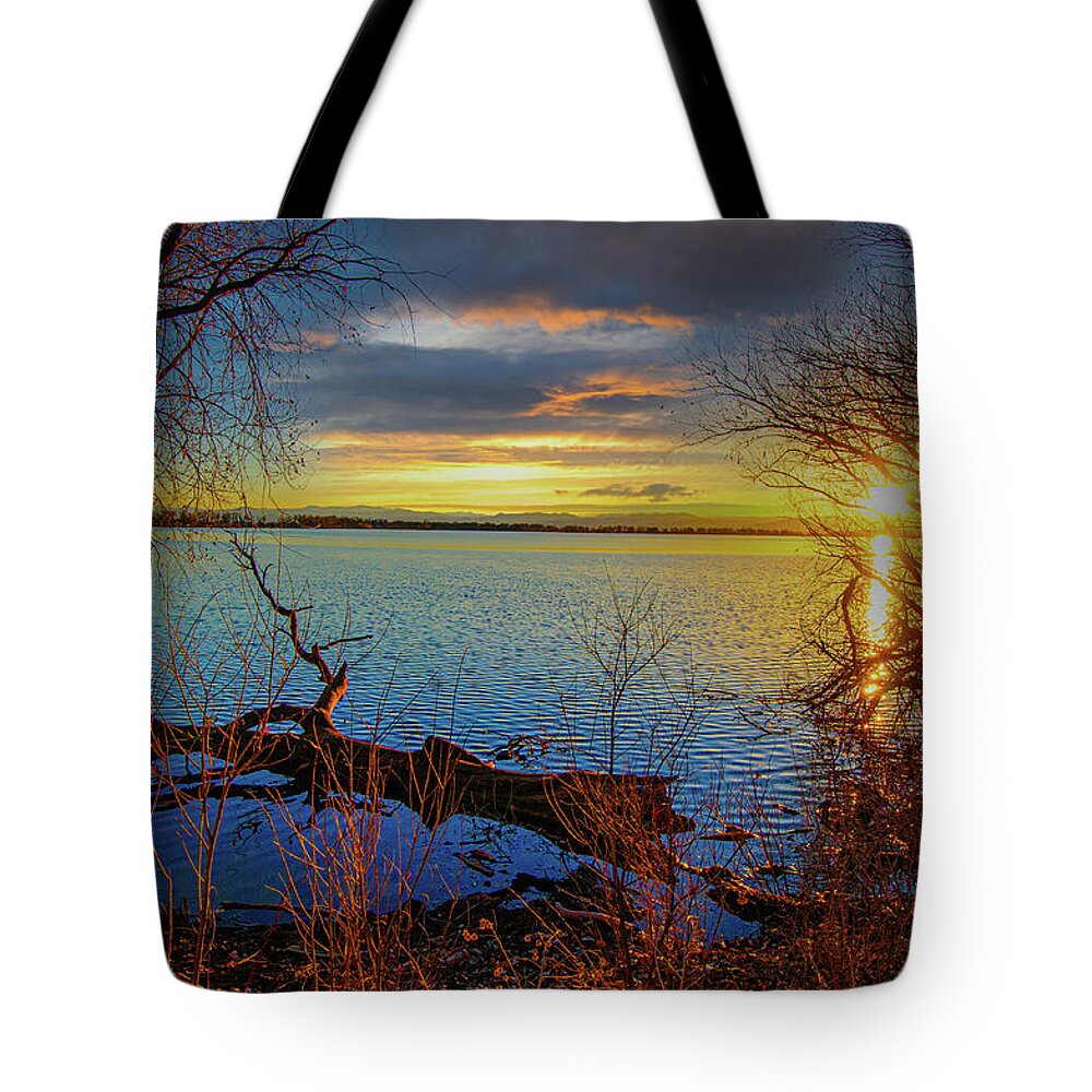 Autumn Tote Bag featuring the photograph Sunset Over Barr Lake 2 Sunset over lake framed by bare tree branches, log floating nearby by Tom Potter