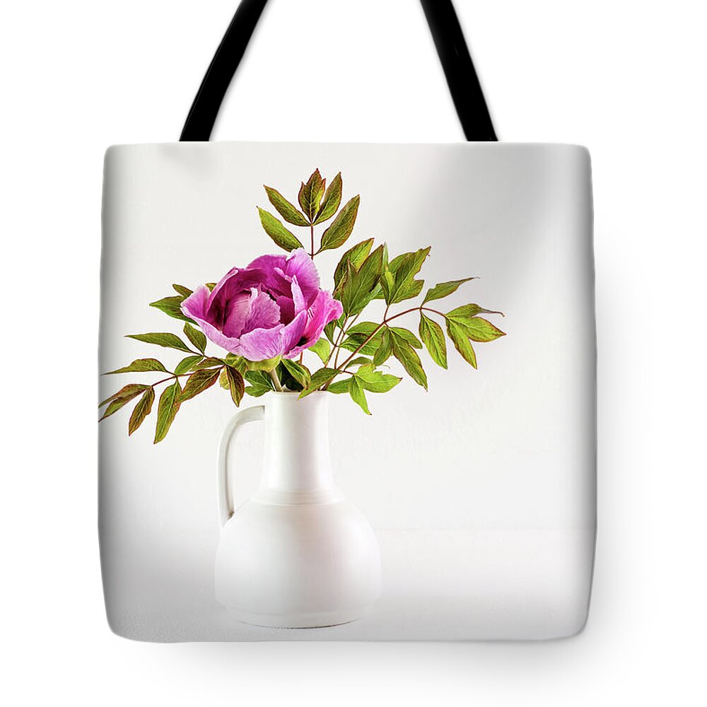 Tree Peony Tote Bag featuring the photograph Tree peony Lan He Paeonia suffruticosa rockii in a white vase by Torbjorn Swenelius
