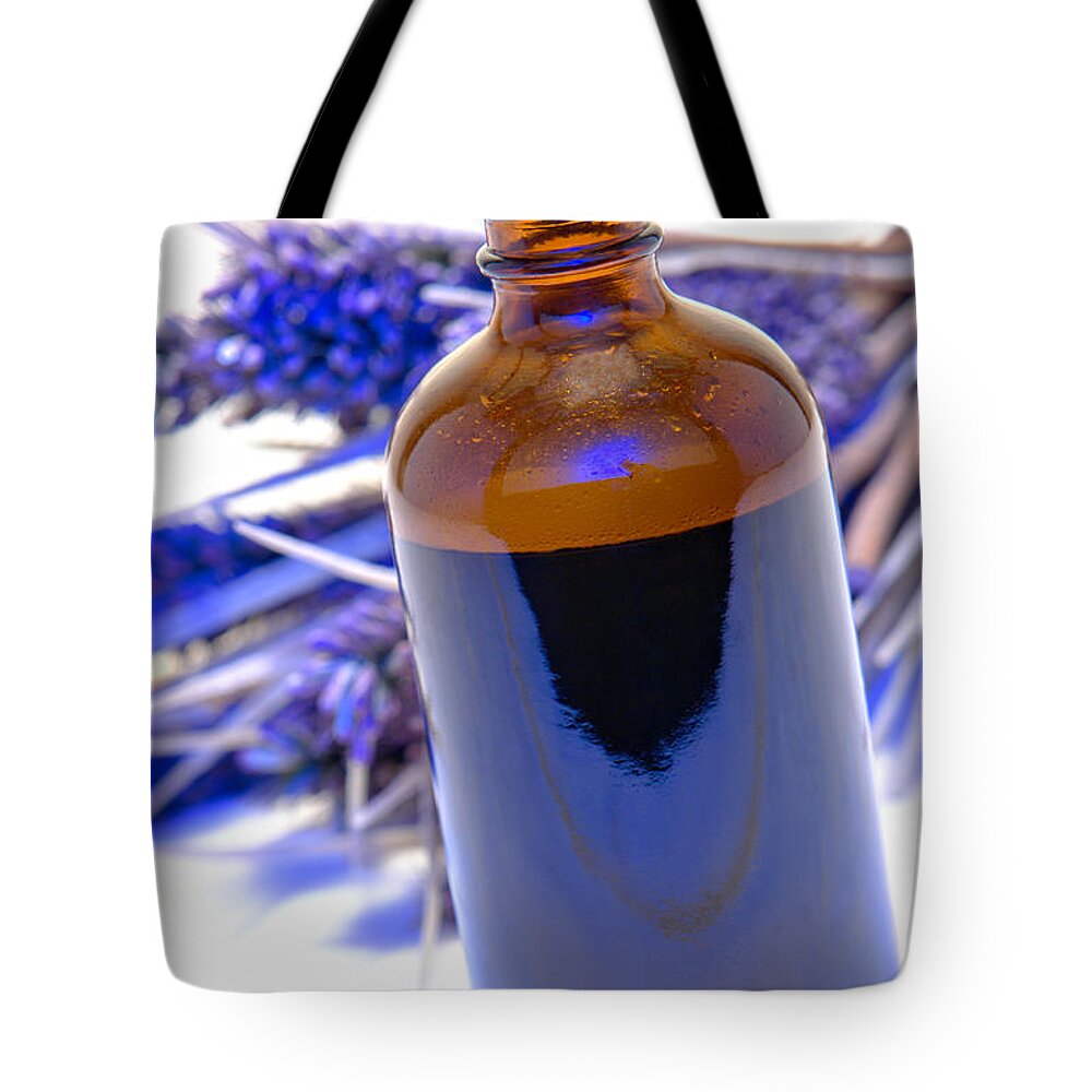 Aromatherapy Tote Bag featuring the photograph Aromatherapy Bottle with Blue Flower Background by Olivier Le Queinec