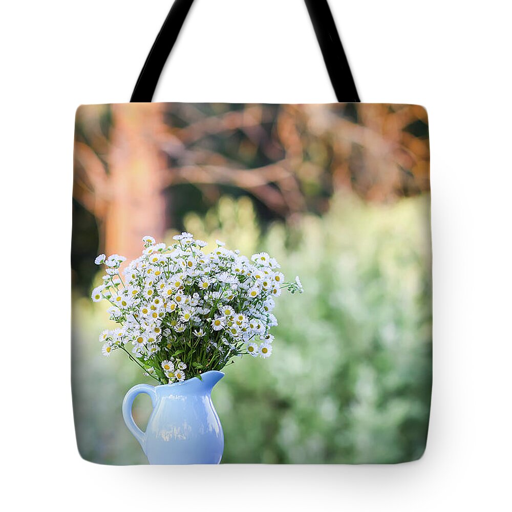 Flower Tote Bag featuring the photograph Bouquet of small white daisy flowers in a blue ceramic vase #4 by Olga Strogonova