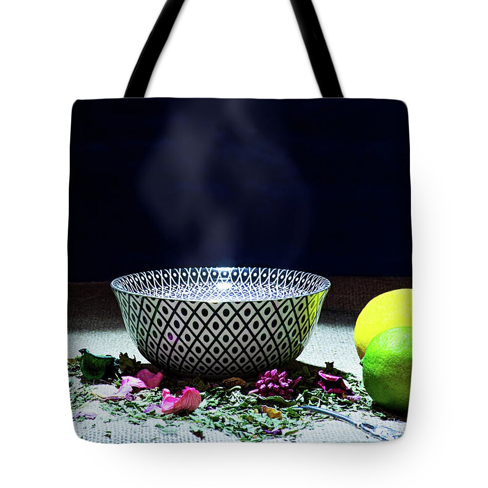 Tea Tote Bag featuring the photograph A drinking bowl with tea and herbs. by Bernhard Schaffer