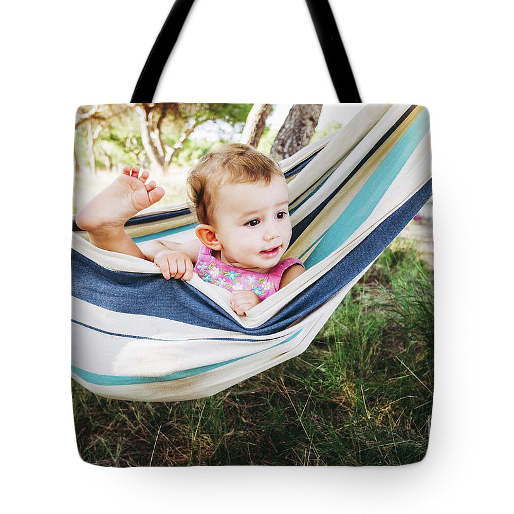 Adorable Tote Bag featuring the photograph Adorable one year old girl inside a hammock smiling and having f by Joaquin Corbalan