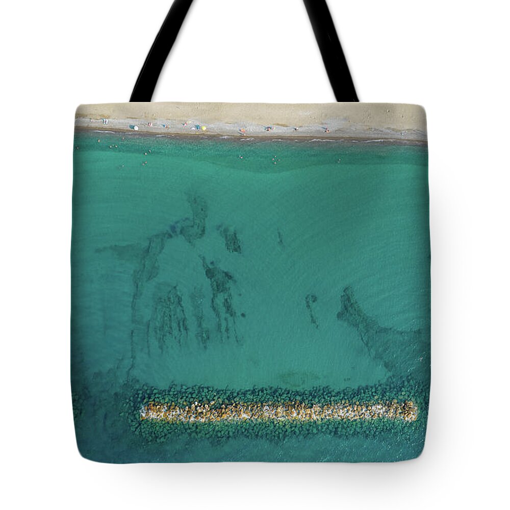 Beachfront Tote Bag featuring the photograph Aerial view from flying drone of people relaxing on the beach. Paphos Cyprus by Michalakis Ppalis