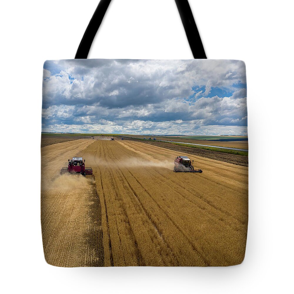 Agriculture Tote Bag featuring the photograph Aerial view of combine on harvest field by Mikhail Kokhanchikov