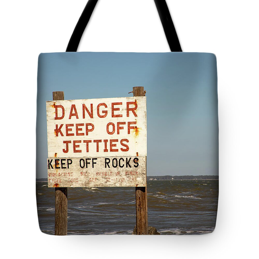 America Tote Bag featuring the photograph Beach hazard sign by Karen Foley