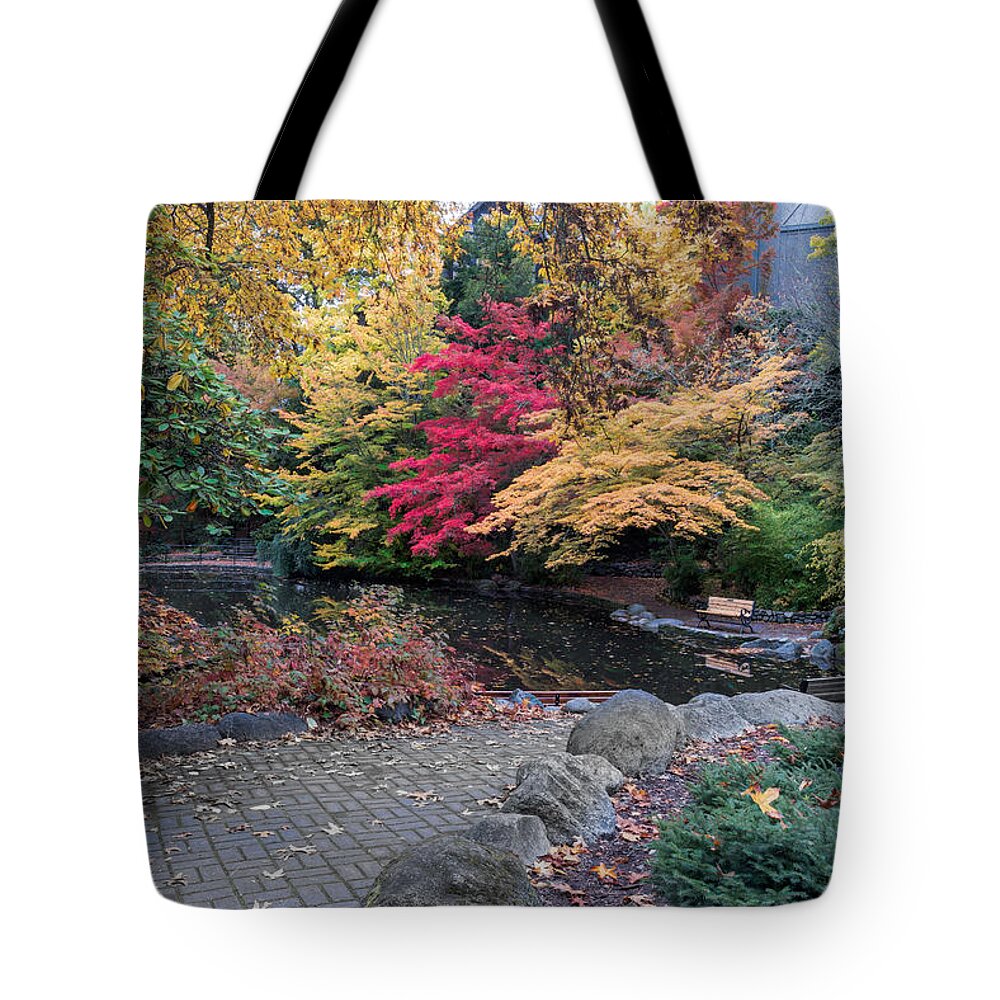 Ashland Tote Bag featuring the photograph Bench at Lithia Park by the lake by Alessandra RC
