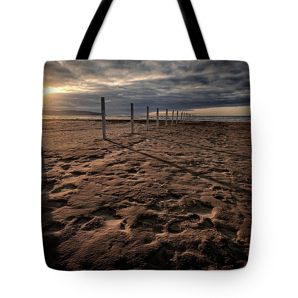 Downhill Tote Bag featuring the photograph Benone Beach Posts by Nigel R Bell