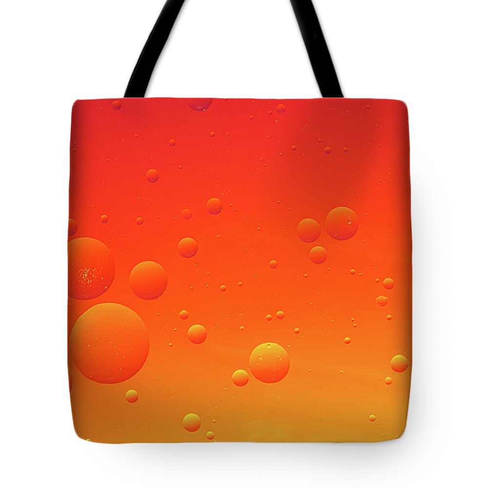 Abstract Tote Bag featuring the photograph Bright abstract, red background with flying bubbles by Michalakis Ppalis