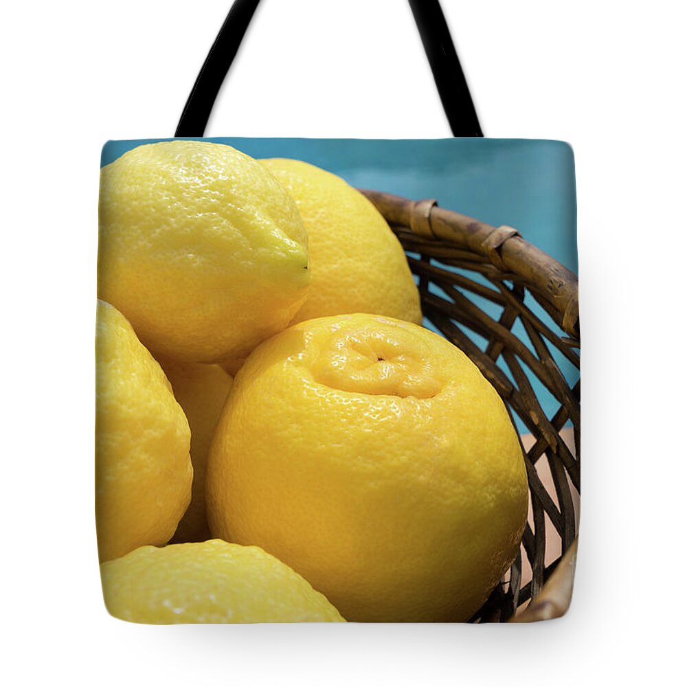 Lemon Tree Tote Bag featuring the photograph Bright yellow lemons in a basket by the pool by Adriana Mueller