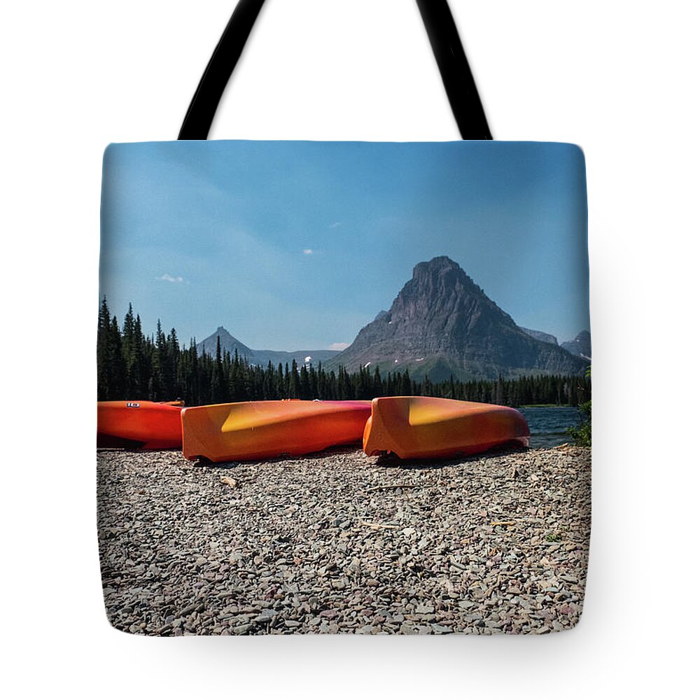 Montana Tote Bag featuring the photograph Canoe on two medicine lake by Alberto Zanoni
