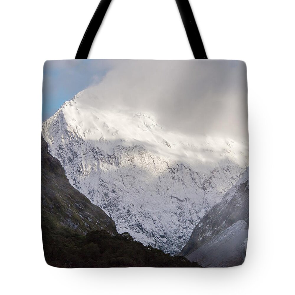 Milford Sound Tote Bag featuring the photograph Clouds and Snow around Milford Sound One by Bob Phillips