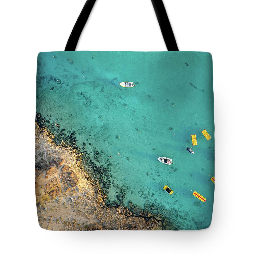 Seascape Tote Bag featuring the photograph Drone aerial of seascape with idyllic blue calm blue water. Fig tree bay beach Protaras Cyprus by Michalakis Ppalis
