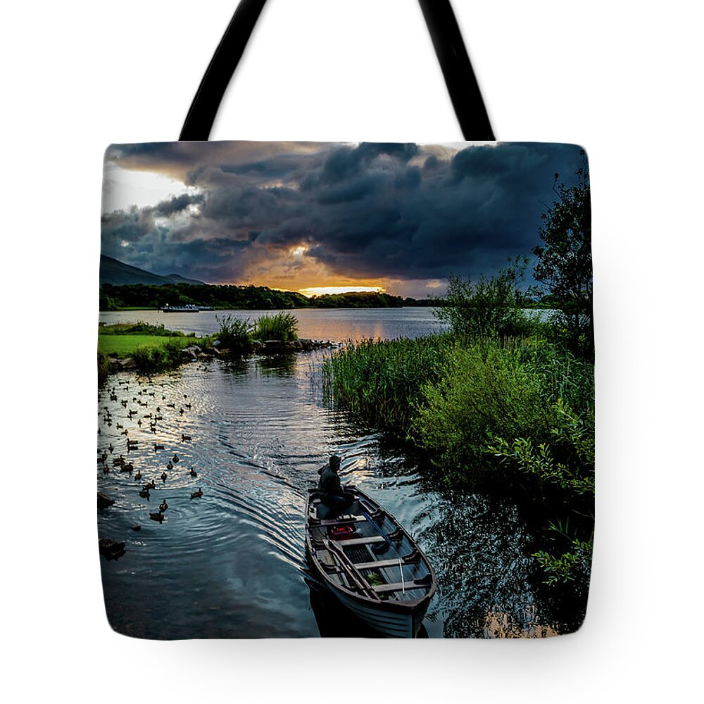 Ireland Tote Bag featuring the photograph Fisher boat returns at sunset from Lough Leane in Killarney National Park in Ireland by Andreas Berthold