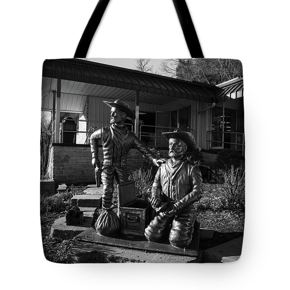 Frank James Tote Bag featuring the photograph Frank and Jesse James statues at Meramec Caverns on Historic Route 66 in black and white by Eldon McGraw