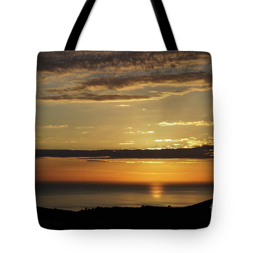 Clouds Tote Bag featuring the photograph Golden sunrise over the sea by Adriana Mueller