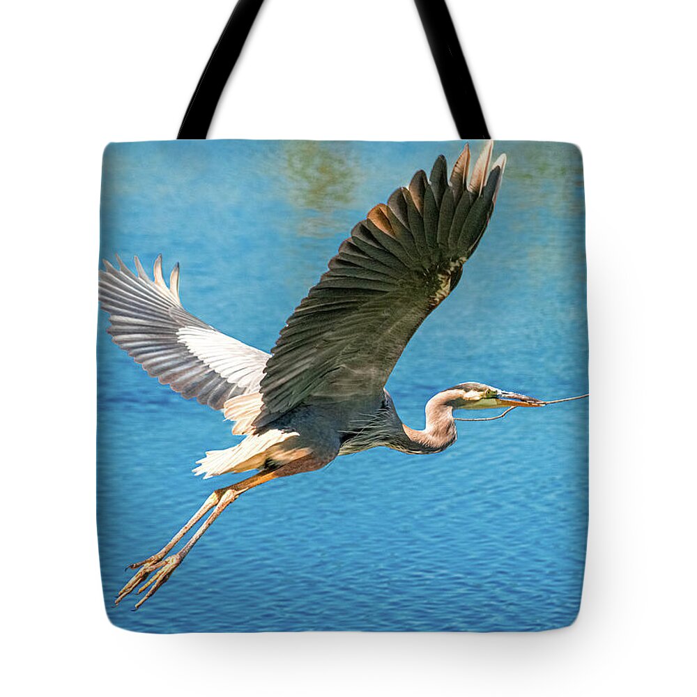 Heron Building Nest Tote Bag featuring the photograph Heron Bearing Gifts by Susan Molnar