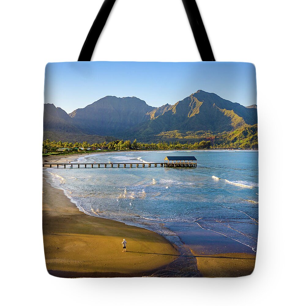 Aerial Tote Bag featuring the photograph Lone man on the sand of Hanalei beach on the nor by Steven Heap