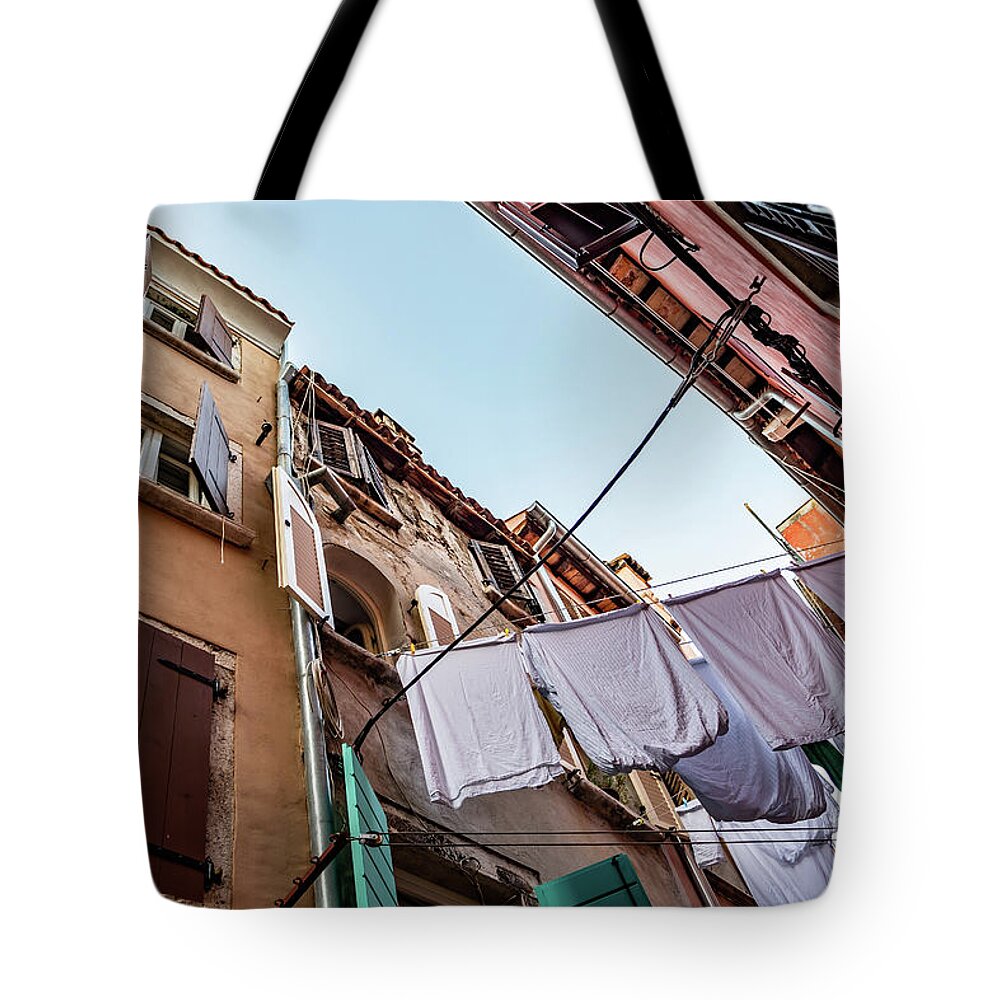 Croatia Tote Bag featuring the photograph Narrow Alley With Old Houses And Freshly Washed Laundry In The City Of Rovinj In Croatia by Andreas Berthold