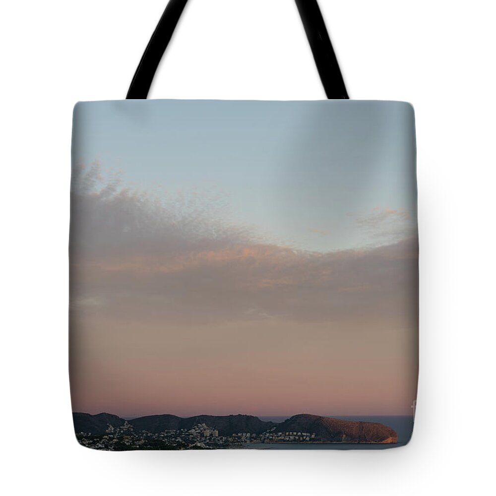 Mediterranean Coast Tote Bag featuring the photograph Pale pink sky and soft clouds at sunset on the Mediterranean coast by Adriana Mueller